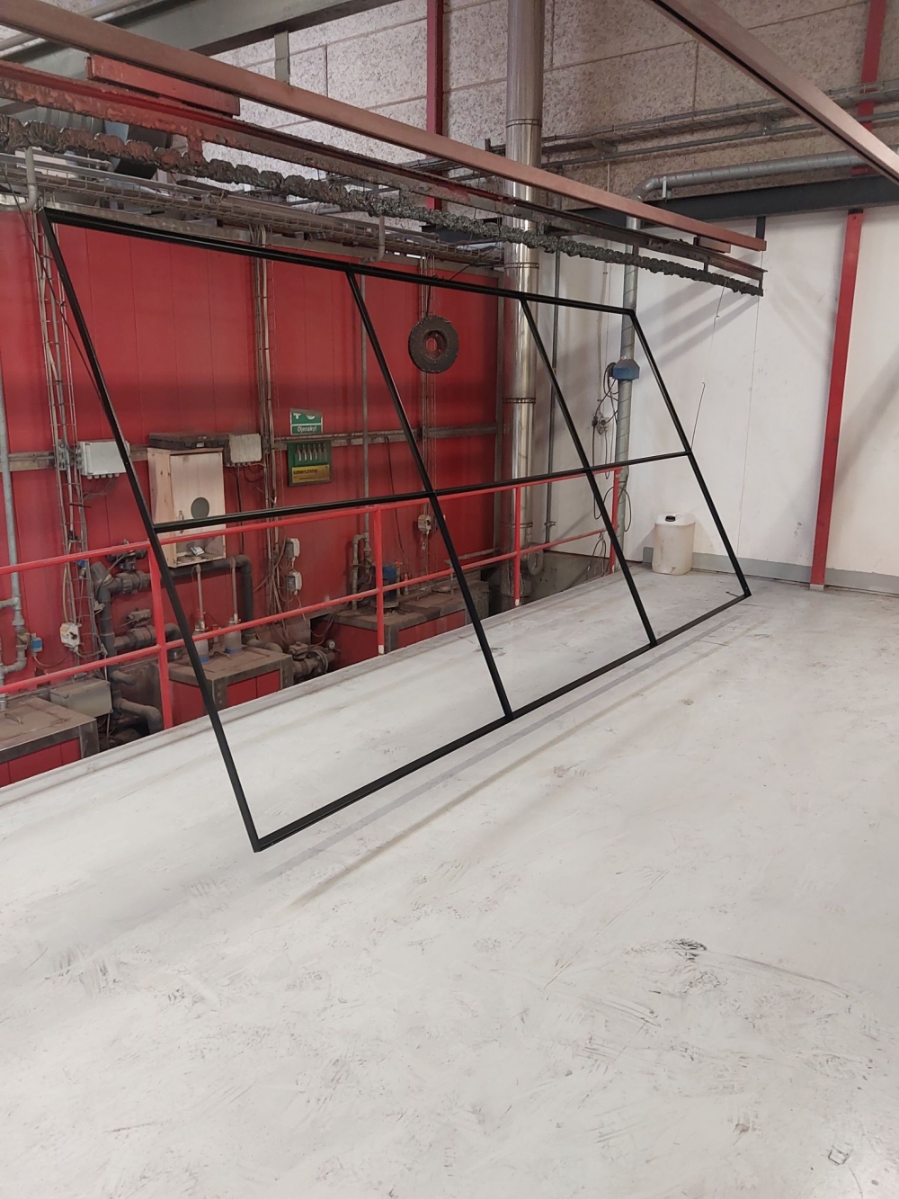 Store sorte rammer efter pulverlakering på værkstedsophæng